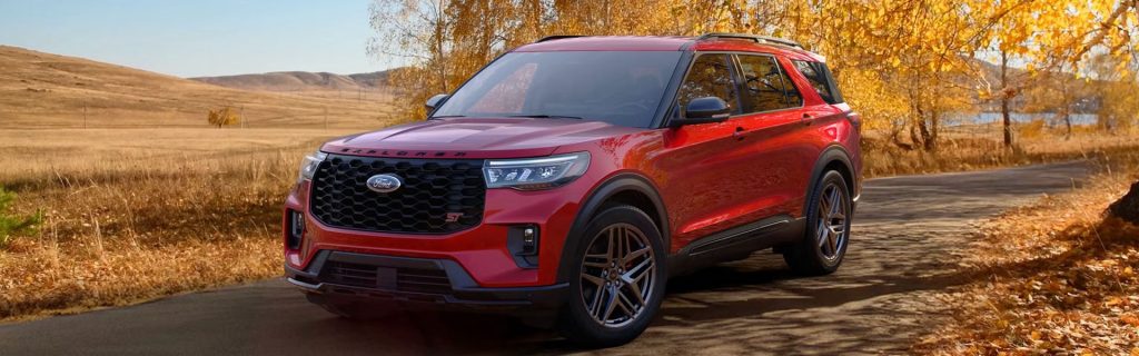 Red Ford Explorer parked on a country road lined with autumn trees