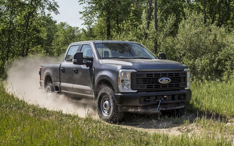 Ford Super Duty pickup driving on a gravel road